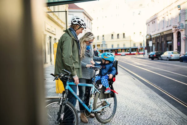 Şehirde açık havada Genç Anne ile bisiklet koltuğuna oturan bir küçük yürümeye başlayan çocuk. — Stok fotoğraf