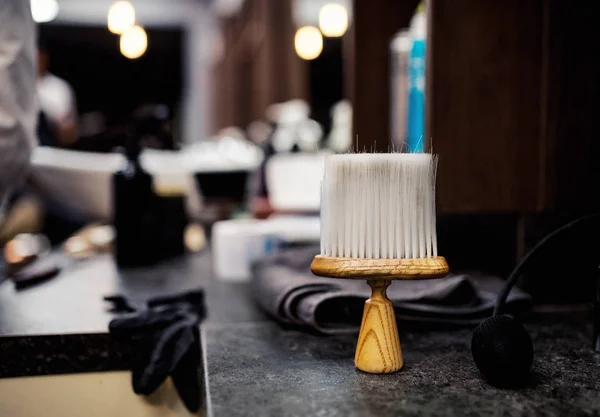 Eine Haarstaubbürste und andere Werkzeuge im Friseursalon für Männer, im Friseursalon. — Stockfoto