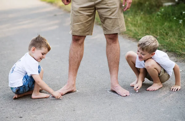 夏の日の公園内の道路上の父と遊ぶ 2 人の小さな息子. — ストック写真