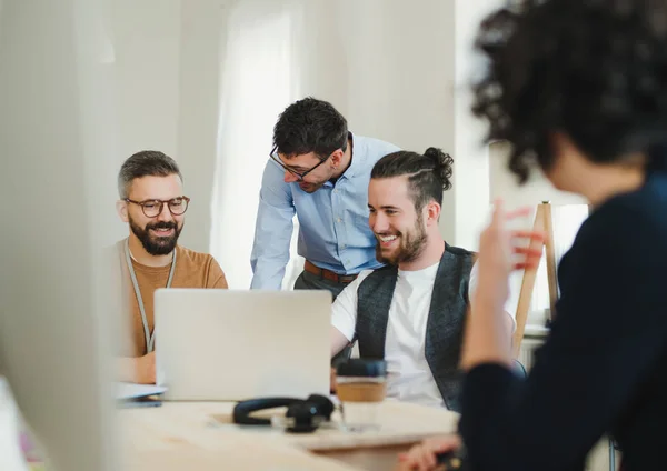 Gruppe junger Geschäftsleute mit Laptop arbeitet zusammen in einem modernen Büro. — Stockfoto