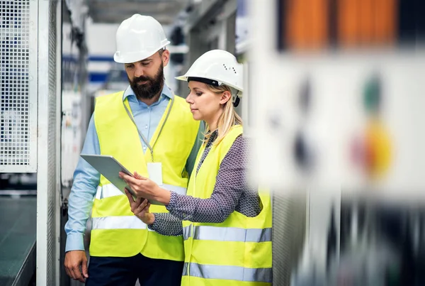 Ritratto di un ingegnere industriale con tablet in fabbrica, che parla . — Foto Stock