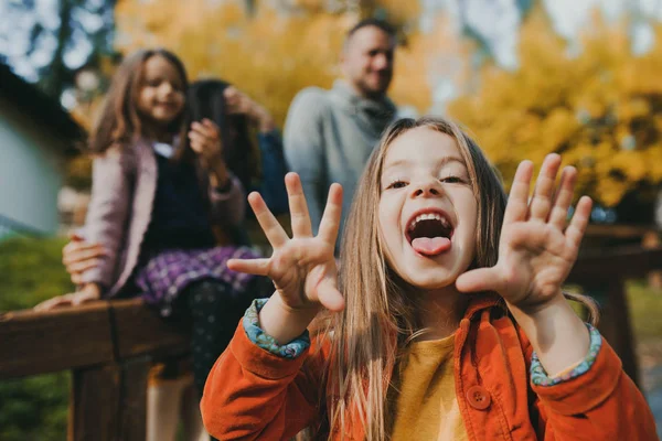 Portrait d'une petite fille avec sa famille en ville en automne . — Photo