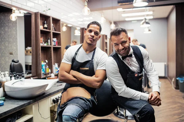 Két férfi haidressers és a fodrászok, fodrászat ül. — Stock Fotó