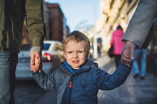 Malé batole chlapce s nepoznání rodiče chůzi venku v městě. — Stock fotografie