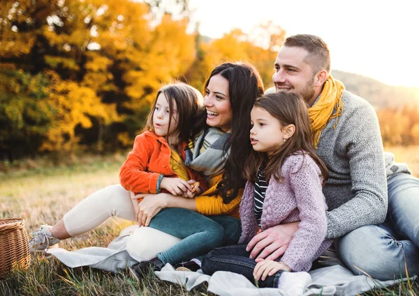 日落时分 幸福的年轻家庭的画像 有两个小孩坐在秋天的大自然地上 — 图库照片