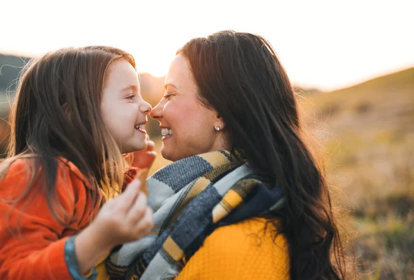 Un retrato de madre joven con una pequeña hija en otoño naturaleza al atardecer. —  Fotos de Stock