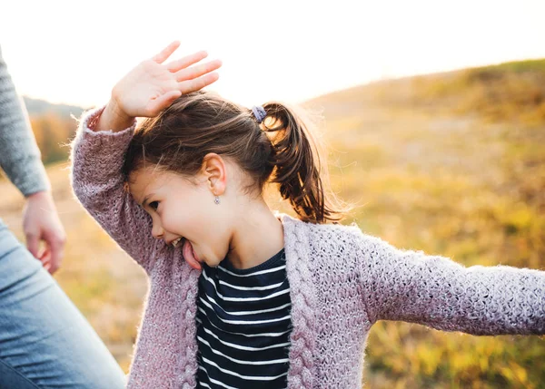 Seorang gadis kecil dengan ayah yang tidak dikenal di alam musim gugur, bersenang-senang . — Stok Foto
