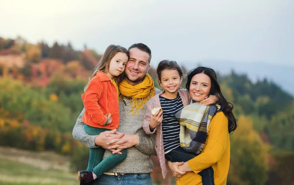 Ett porträtt av ung familj med två små barn i höst naturen. — Stockfoto