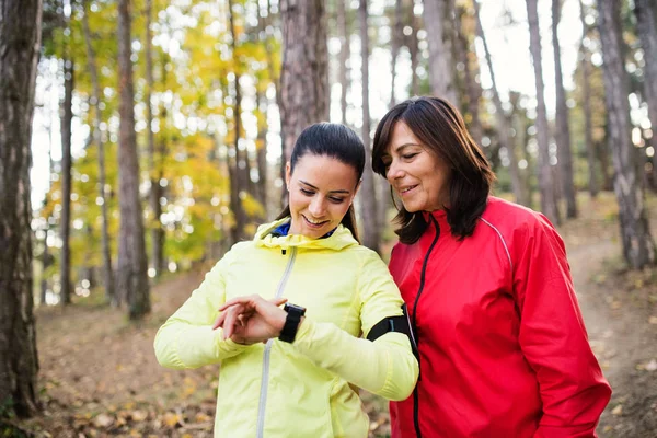 Zaman kontrol kadın koşucular smartwatch açık havada doğa, ormandaki ile. — Stok fotoğraf