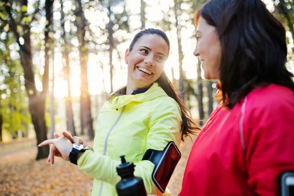 Vrouwelijke lopers met smartwatch buiten in het bos in de natuur, de tijd controleren. — Stockfoto