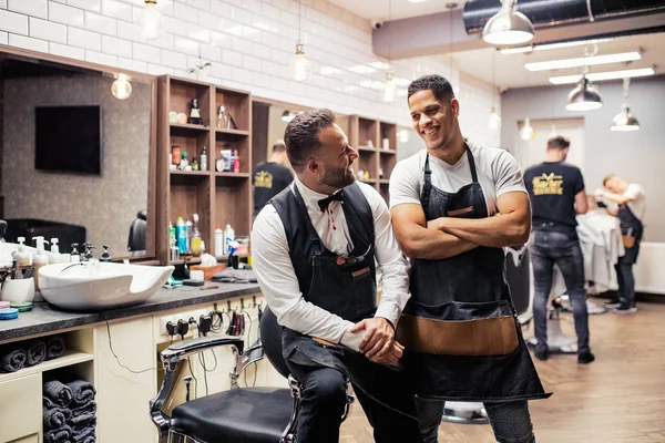 Due haidresser e parrucchieri maschili seduti in barbiere . — Foto Stock