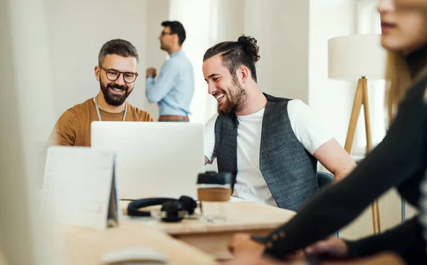 Grupa młodych przedsiębiorców z laptopa ze sobą pracę w nowoczesnym biurze. — Zdjęcie stockowe