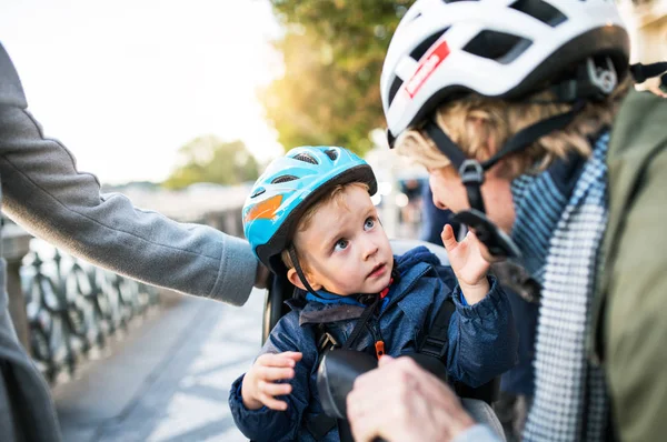 市内で屋外はヘルメット若い両親と小さな幼児の少年. — ストック写真