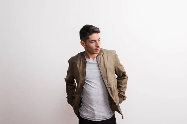 A confident young hispanic man in a studio, hands in pockets. — Stock Photo, Image