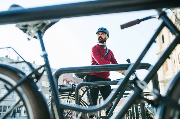Hipster homem de negócios pendulares estacionamento bicicleta elétrica na cidade quando vai trabalhar . — Fotografia de Stock