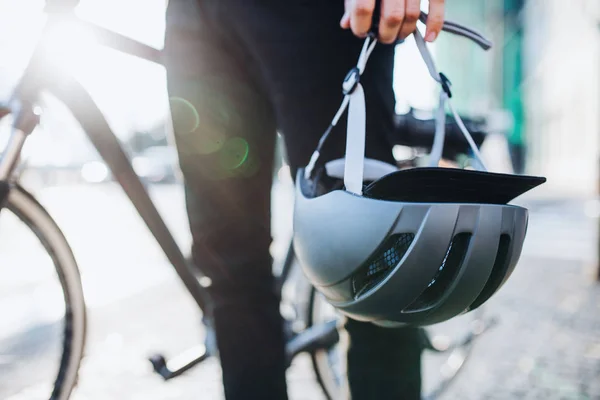 Midsection de hombre viajero o mensajero con bicicleta eléctrica y casco en la ciudad . — Foto de Stock