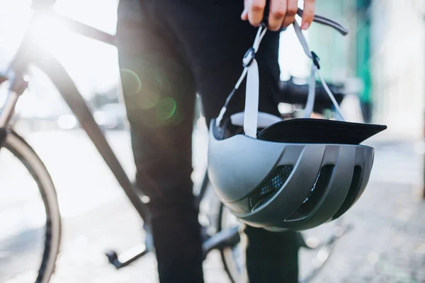 Midsection of man commuter or courier with electric bicycle and helmet in city. — Stock Photo, Image