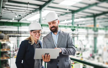 Bir portresini endüstriyel erkek ve kadın mühendis bir fabrikada tablet ile çalışma.