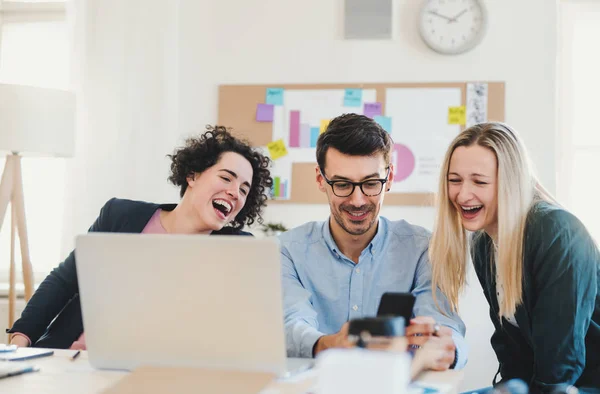 Groep van jonge ondernemers met laptop samen te werken in een modern kantoor. — Stockfoto