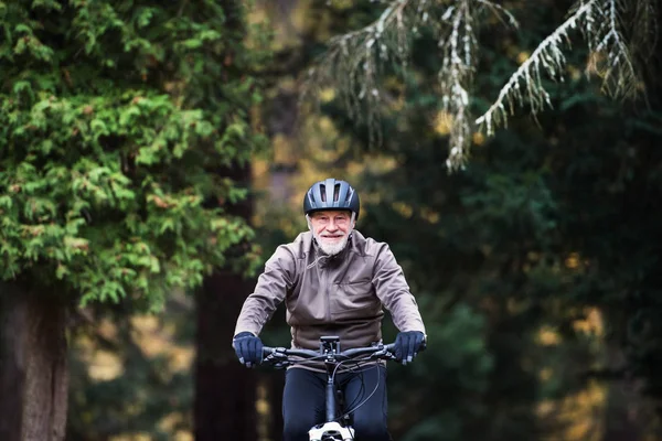 自然の道に屋外サイクリング electrobike とアクティブな年配の男性. — ストック写真