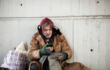 Açık havada oturma, alkol tutan evsiz dilenci adam açık bir bakış. Kopya alanı.