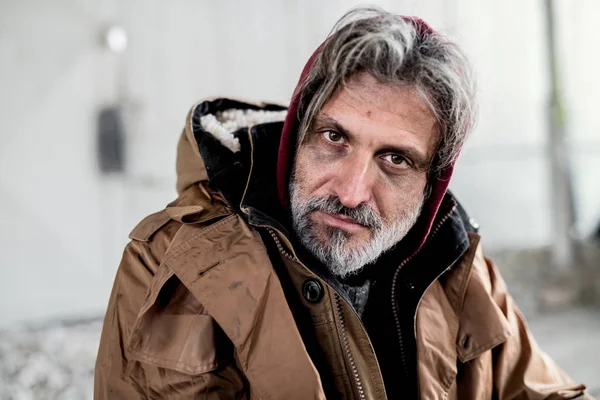 Een portret van dakloze bedelaar man zitten buiten. — Stockfoto