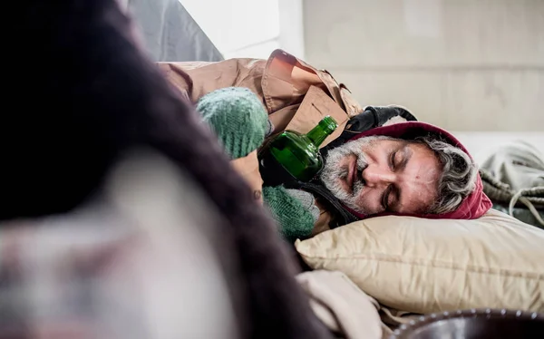 Homme mendiant sans abri avec bouteille couché sur le sol à l'extérieur dans la ville, dormir . — Photo