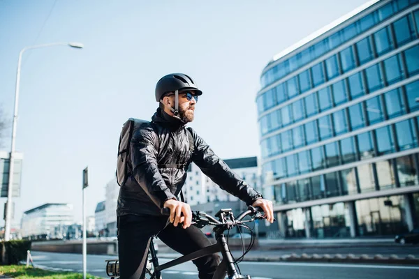 Männlicher Kurier mit Fahrrad, der Pakete in der Stadt ausliefert. Kopierraum. — Stockfoto