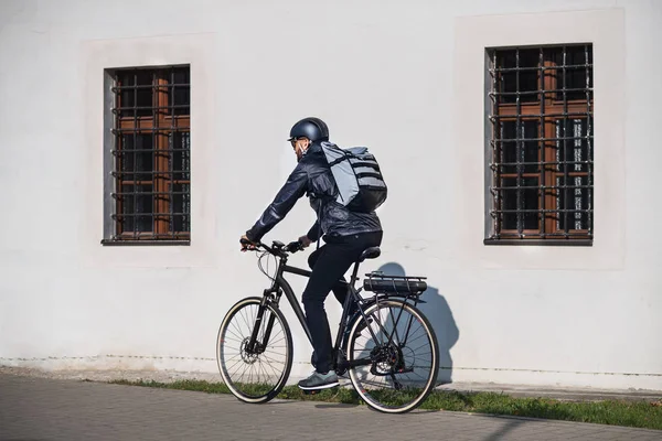 Manliga courier med cykel leverera paket i city. — Stockfoto