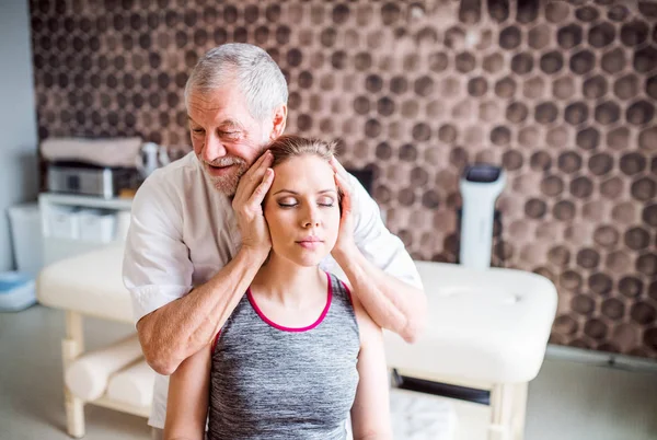 Senior male physiotherapist working with a female patient. — Stock Photo, Image
