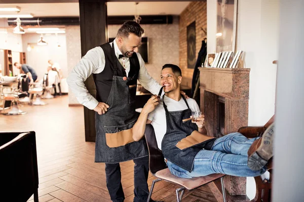 Dos haidresser y peluquero en la peluquería, fumar una pipa y hablar . — Foto de Stock