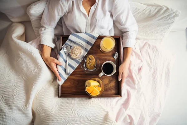 Une section médiane de la femme avec petit déjeuner au lit le matin, en utilisant un smartphone. Une vue de dessus . — Photo