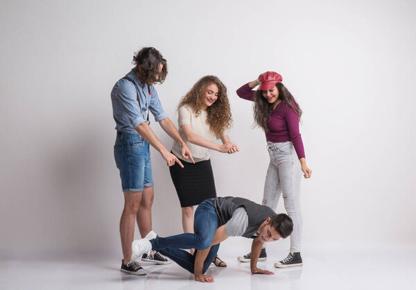 A group of young people with a friend dancing breakdance in a studio.