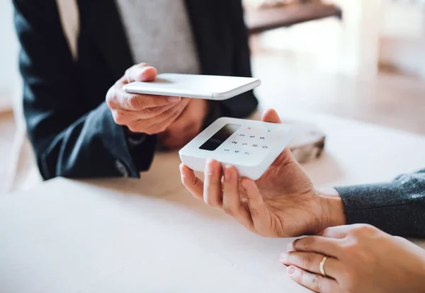 Een buik van klant en winkelbediende maken van mobiel betalen in een winkel. — Stockfoto