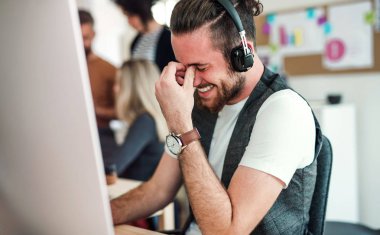 Kulaklıklar ve modern bir ofis arkadaşları ile genç işadamı.