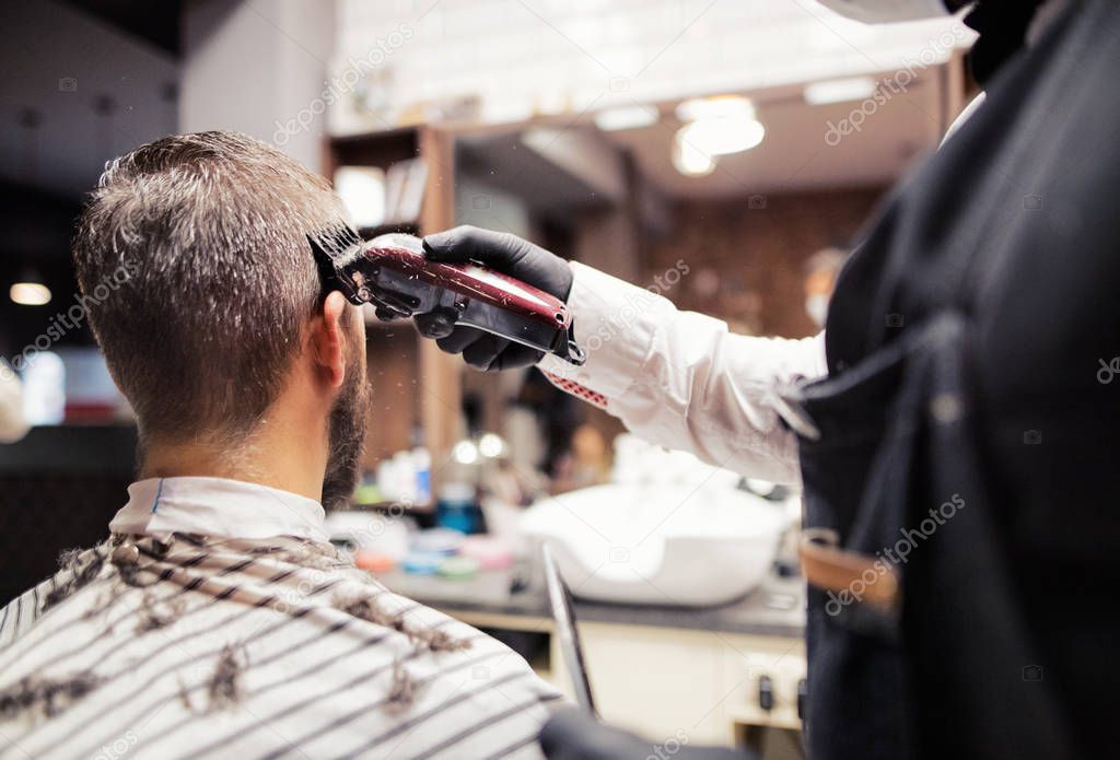 Hipster man client visiting haidresser and hairstylist in barber shop.