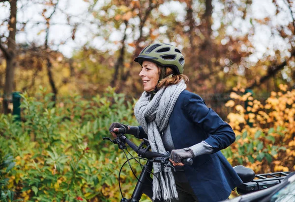 Aktivní senior žena s electrobike venku na kole v parku. — Stock fotografie