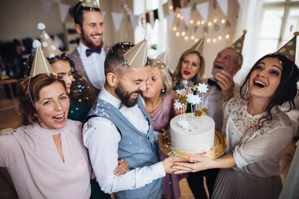 Un retrato de familia multigeneracional con un pastel en una fiesta de cumpleaños en interiores . — Foto de Stock