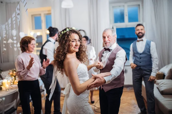 Une jeune mariée danse avec son grand-père et d'autres invités lors d'une réception de mariage . — Photo