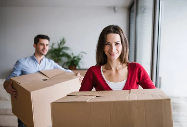Jong (echt) paar met kartonnen dozen verplaatsen in een nieuw huis. — Stockfoto