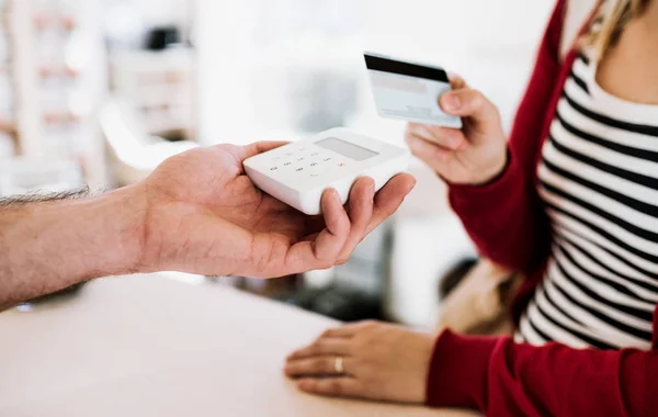 Asistente de cliente y tienda haciendo el pago sin contacto usando tarjeta de crédito en una tienda . — Foto de Stock