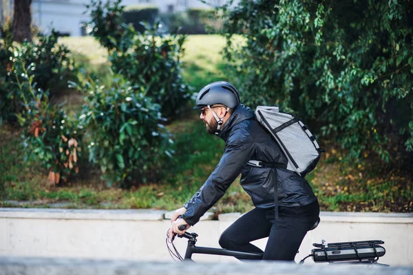 Mensajero de bicicleta macho entregando paquetes en la ciudad. Copiar espacio . — Foto de Stock