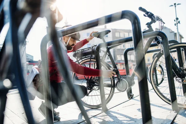 Hipster affärsman pendlare parkering elcykel i city när ska arbeta. — Stockfoto