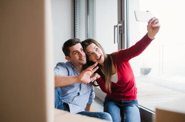 Selfie alarak yeni bir ev taşıma karton kutular ile genç çift. — Stok fotoğraf