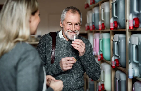 Junge Verkäuferin bedient einen älteren Mann in einem Null-Müll-Laden. — Stockfoto