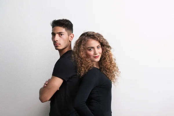 Retrato de una joven pareja de espaldas en un estudio, vestida con ropa negra . —  Fotos de Stock