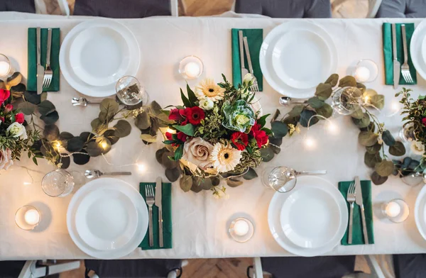 Stół ustawiony na posiłek wewnątrz w pokoju na imprezę, wesele lub rodzinne uroczystości. — Zdjęcie stockowe