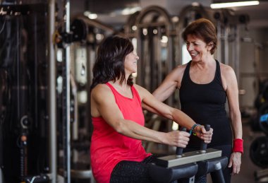 Spor salonunda iki neşeli yaşlılar kadın güç egzersiz yapıyor.
