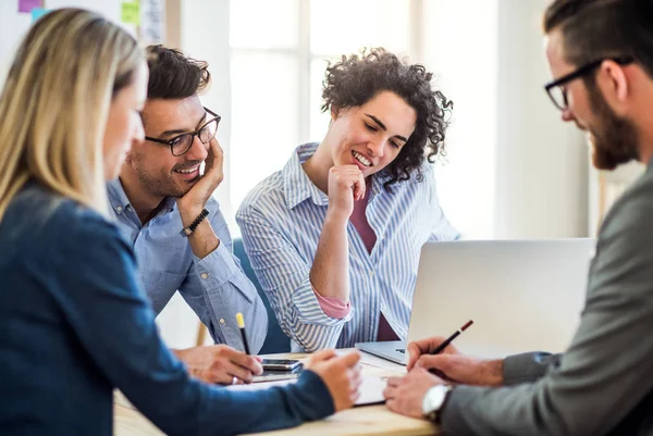 Gruppen av unga företagare med laptop arbetar tillsammans i ett modernt kontor. — Stockfoto