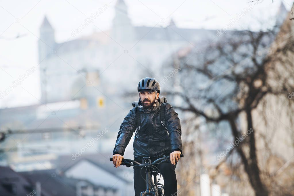 Male courier with bicycle delivering packages in city. Copy space.